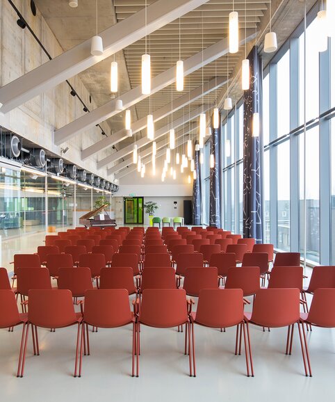 Universität Amsterdam | © Etienne Oldeman Photography Reihen aus roten Stühlen. | © Etienne Oldeman Photography
