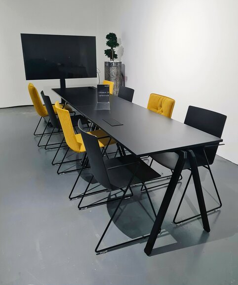 Clerkenwell Design Week Black table with black and yellow skid base chairs.