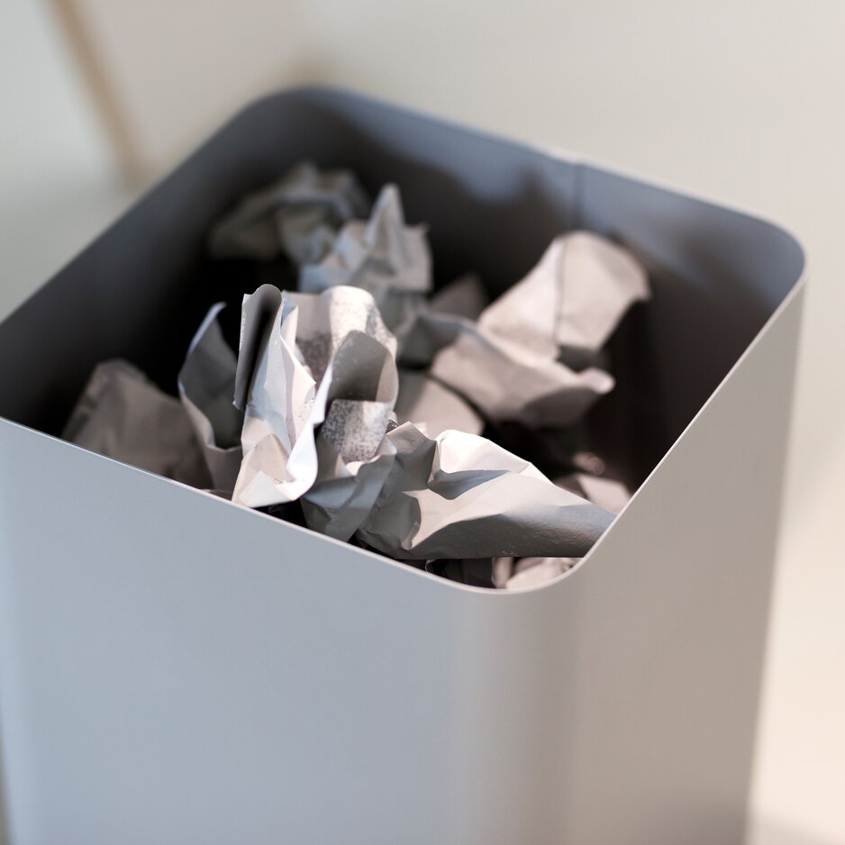 Detailed view of a gray waste paper basket.