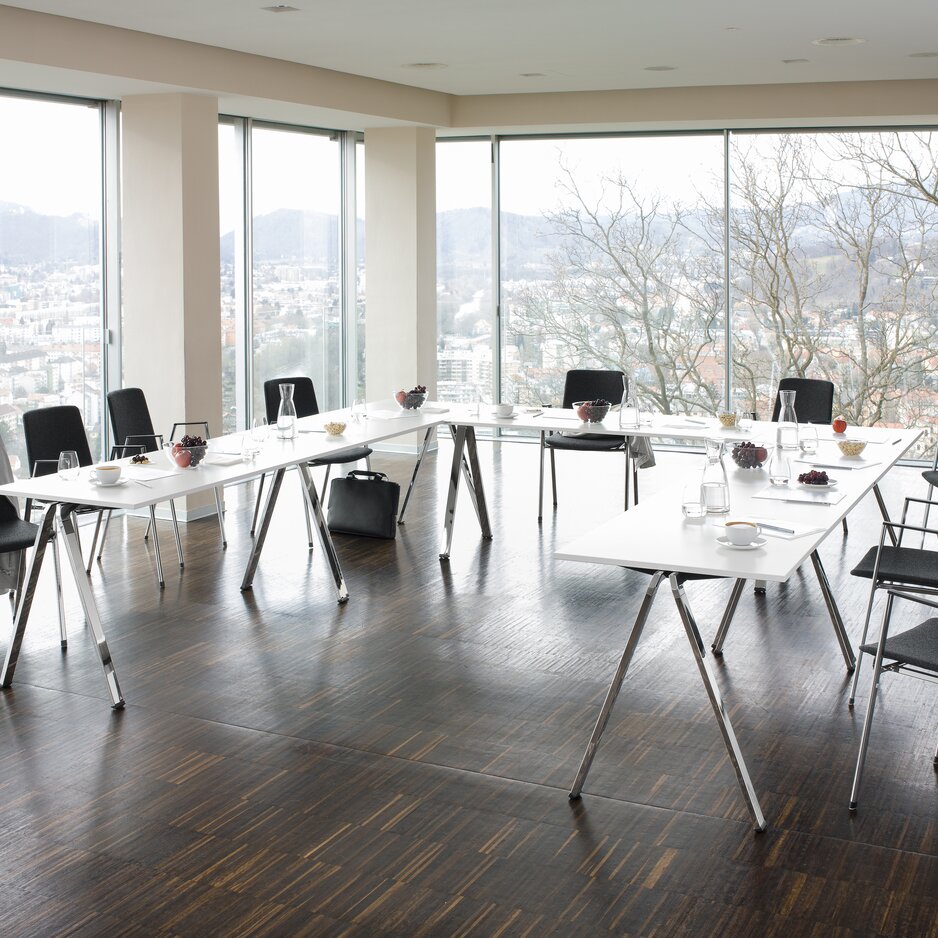 arrangement de conférence avec des tables rectangulaires et des chaises rembourrées gris