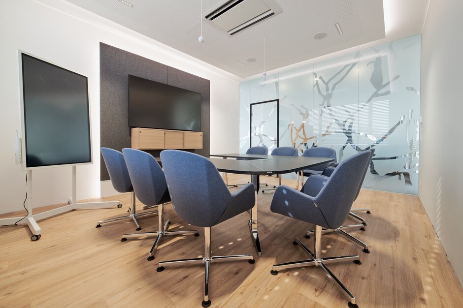 Blue conference chairs at a dark conference table. 