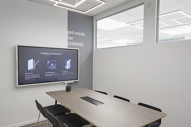 Meeting room with black barstools and a high table.