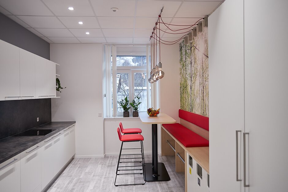 Kitchen with red bench, high table and red barstools. | © Metcon