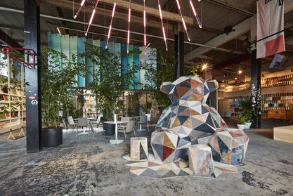 Foyer avec une grande sculpture d’ours. | © BLINK Fotografie