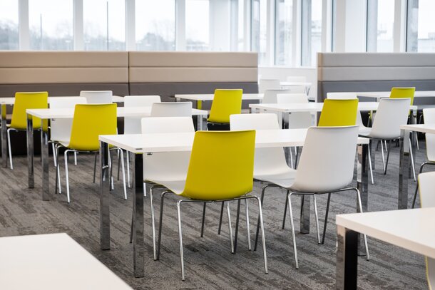 Canteen with white tables and yellow and white chairs. | © Ford Motor Company Limited