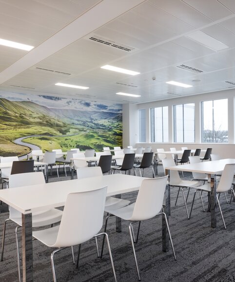 cantine avec tables blanches et chaises blanches et noires | © Ford Motor Company Limited