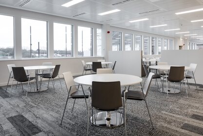 White bistro tables with brown chairs. | © Ford Motor Company Limited