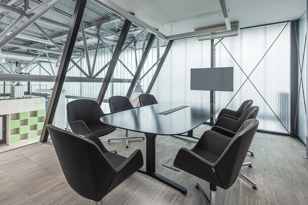 Meeting room with a dark conference table and dark conference chairs.