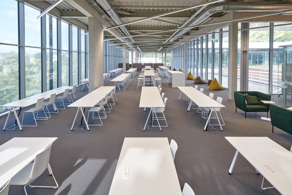 rangées de tables blanches dans une pièce avec beaucoup de fenêtres | © raumpixel.at