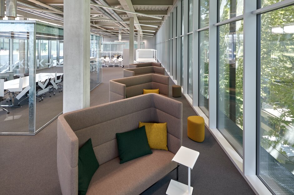 Brown lounge seating in front of windows. | © raumpixel.at