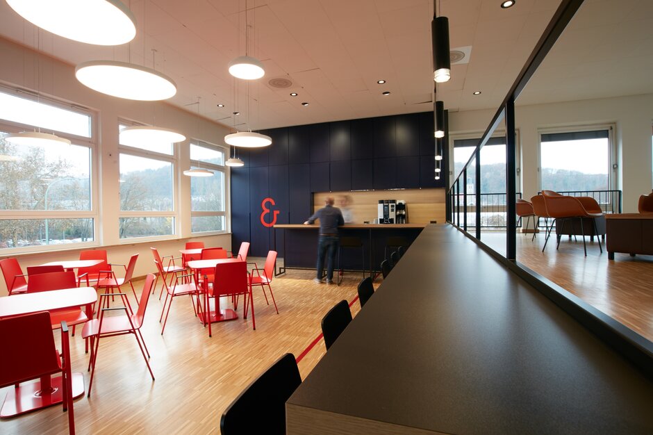 Cantine Koenig & Bauer | © Peter Becker GmbH Cantine avec chaises rouges et tables noires | © Peter Becker GmbH