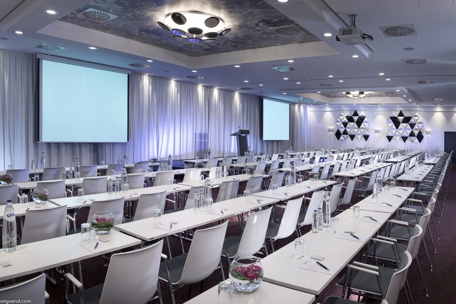 Salle séminaire avec rangées de tables et écran | © studio-bergoend.com