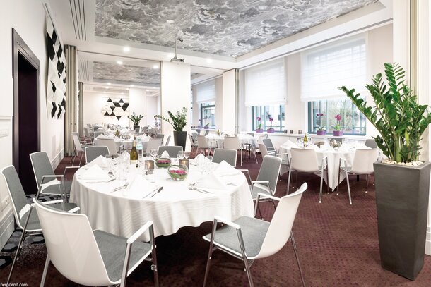 Radisson Blu Royal Hotel Ingerichte eetzaal met ronde eettafel en witte stoelen.