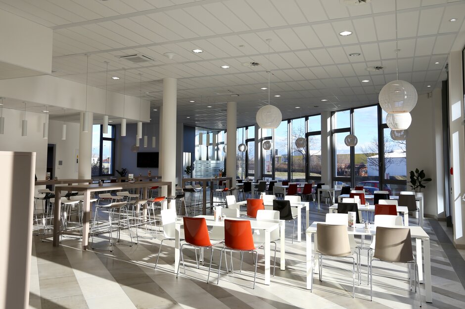 TÜV Austria Cantine avec des tables, des chaises et des tabourets de bar