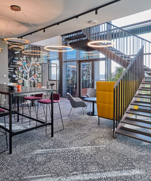Cafebereich mit Treppe im Coworkingbüro. | © raumpixel.at