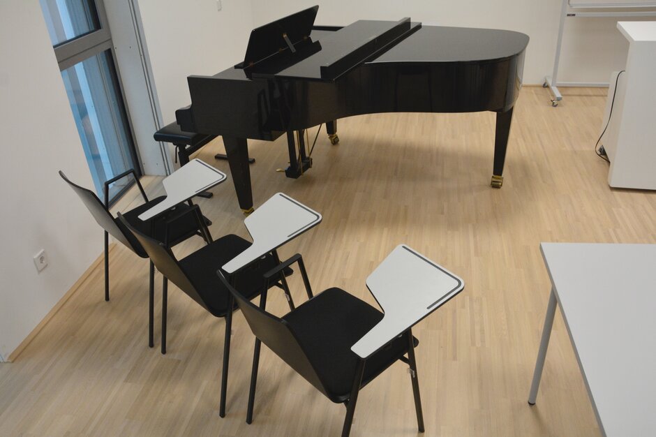 Two black chairs in front of a piano. | © Roland Halbe Fotografie