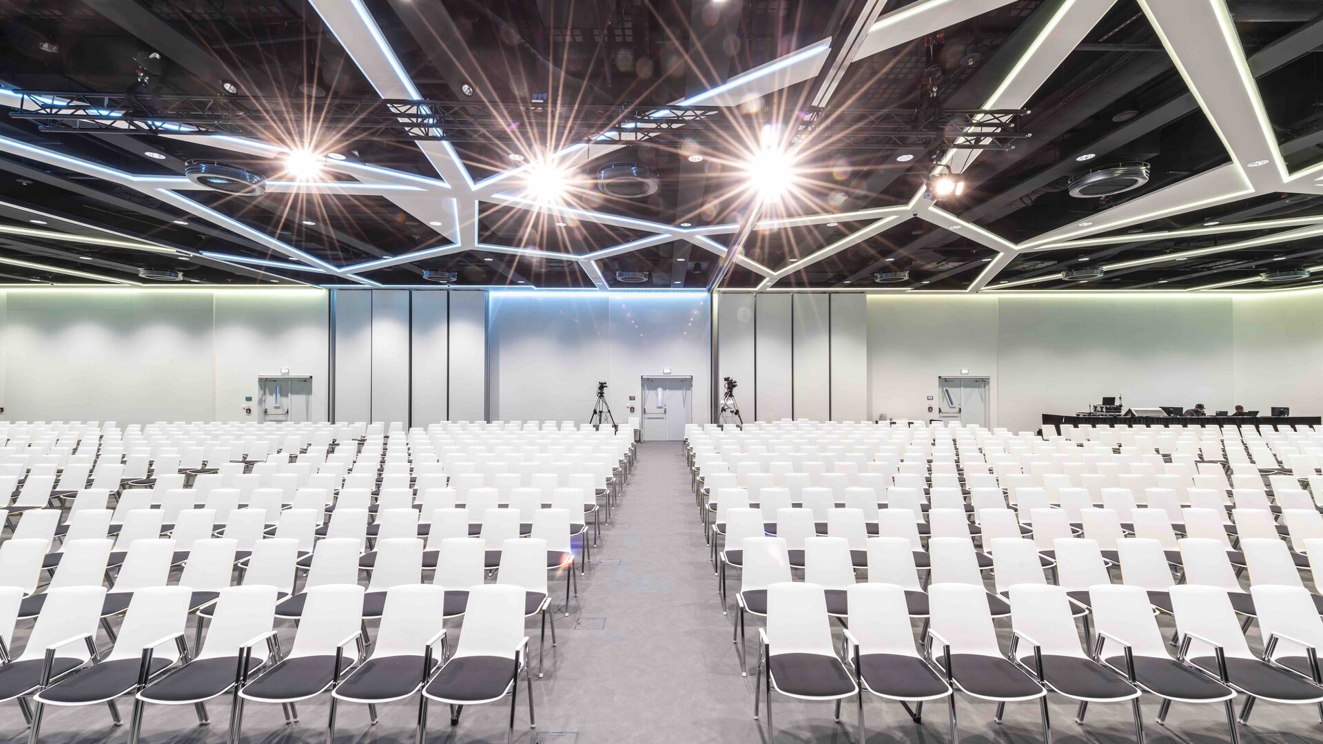 Big hall with white row chairs.