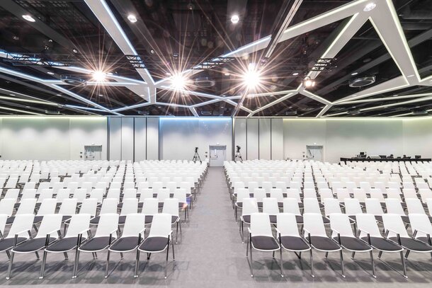 Big hall with white row chairs.