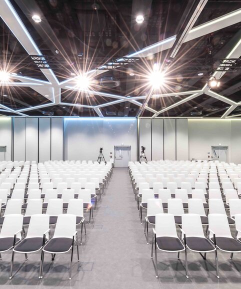 Cubex Saal Großer Veranstaltungssal mit weißen Stühlen.