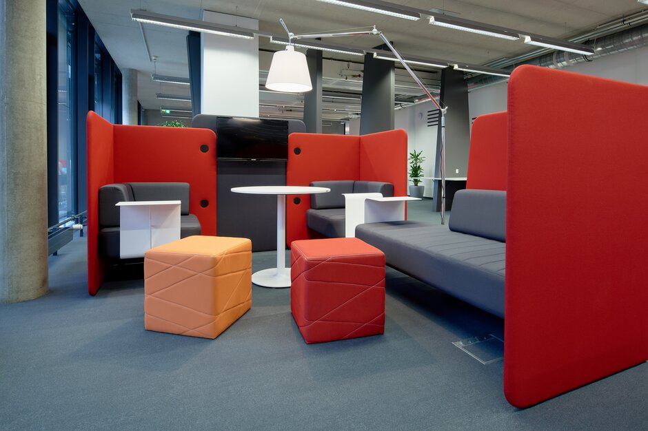 Red and orange lounge seating with white tables. | © raumpixel.at