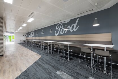 Ford Kantine | © Ford Motor Company Limited Weiße Bartische mit braunen Barhockern und Bänken. | © Ford Motor Company Limited