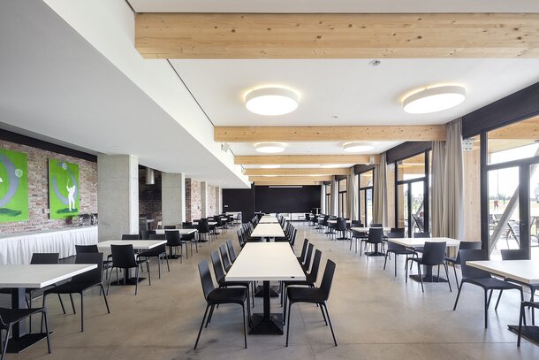 Restaurant with white tables and black chairs.