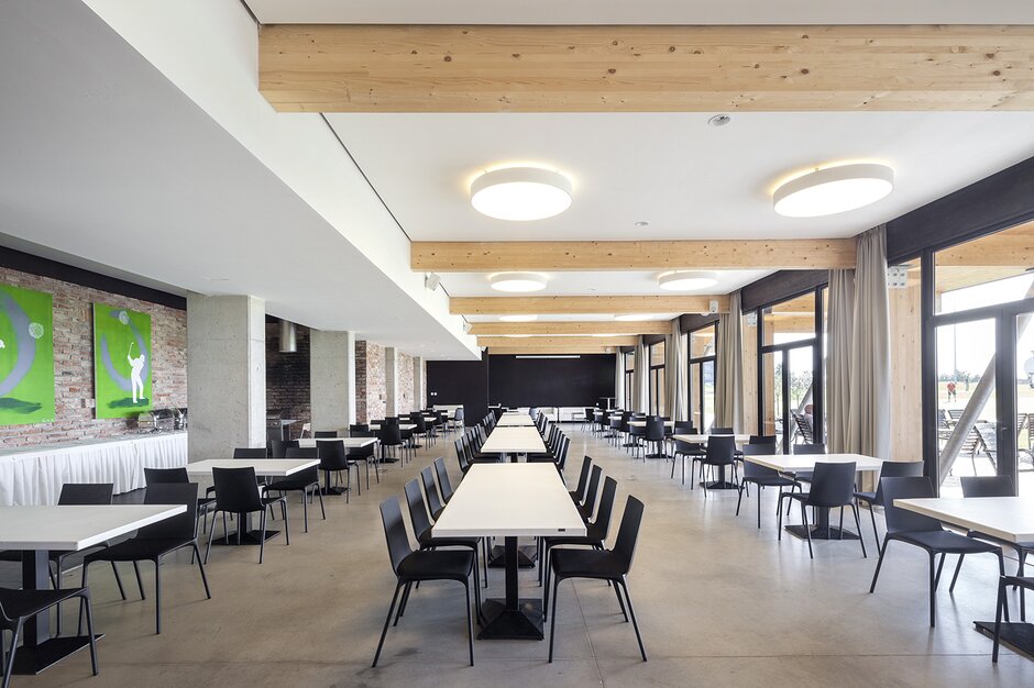 Golfresort Mladá Boleslav Schwarze Tische und Stühle in einem großen Speisesaal.