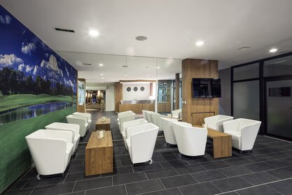 Bar with white armchairs and wooden tables.