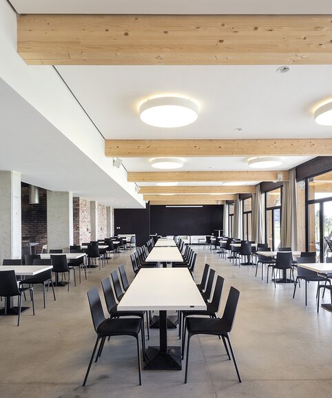 Restaurant with white tables and black chairs.