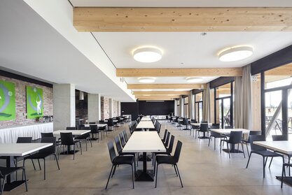 Restaurant with white tables and black chairs.