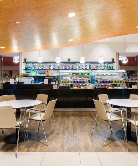 Vitrine in een bedrijfsrestaurant met bistromeubels op de voorgrond | © Gellért Áment