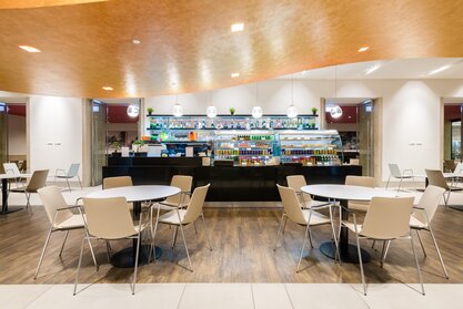Vitrine in een bedrijfsrestaurant met bistromeubels op de voorgrond | © Gellért Áment