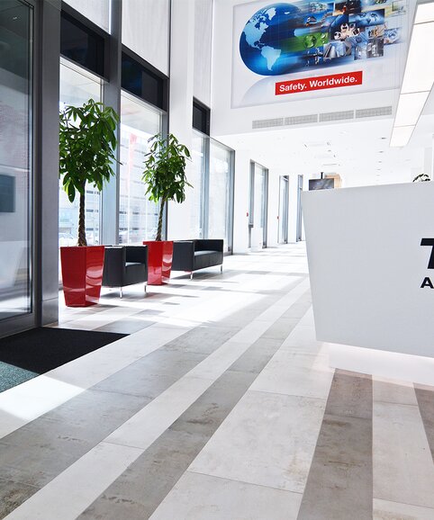 TÜV Austria Heller Empfangsbereich mit roten Elementen.