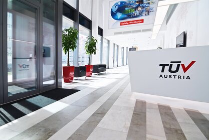 TÜV Austria Heller Empfangsbereich mit roten Elementen.