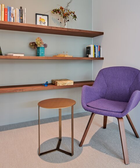 Purple conference chair in front of a wooden bookshelf. | © raumpixel.at