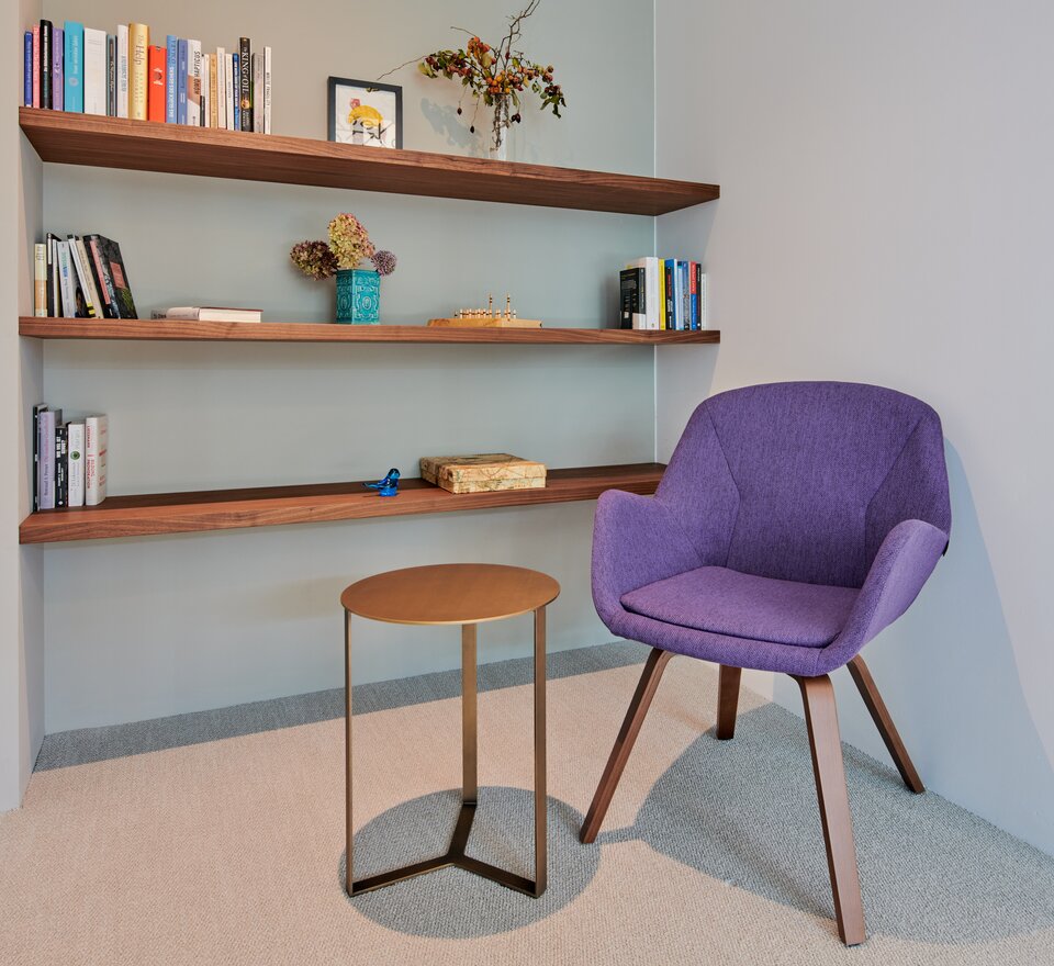 Purple conference chair in front of a wooden bookshelf. | © raumpixel.at