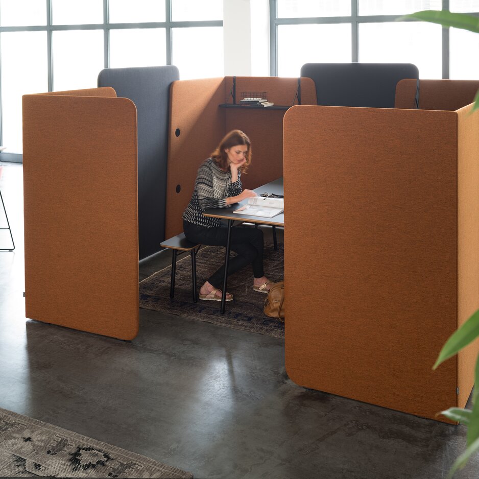 Person is working in a meeting box surrounded by screens.