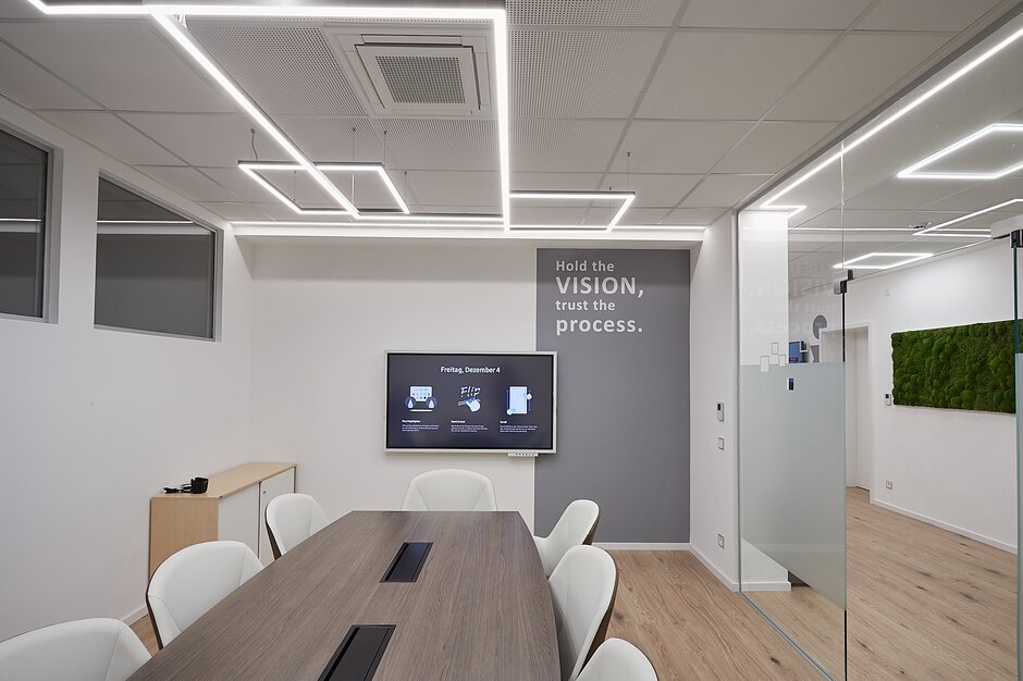 Salle de conférence avec grande table de conférence et écran. | © Metcon