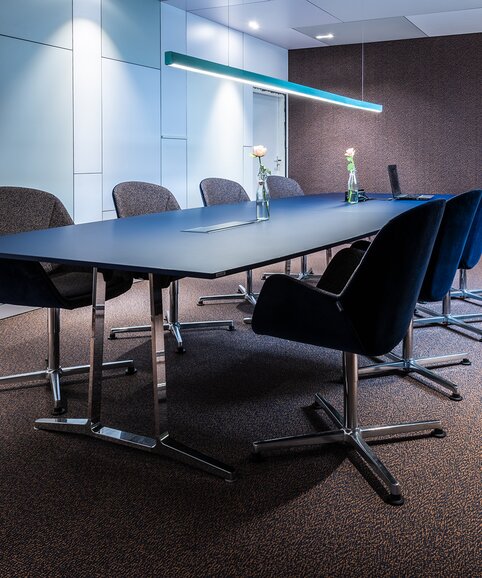 Conference room with gray chairs and a dark conference table. | © BLINK Fotografie