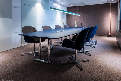 Conference room with gray chairs and a dark conference table. | © BLINK Fotografie