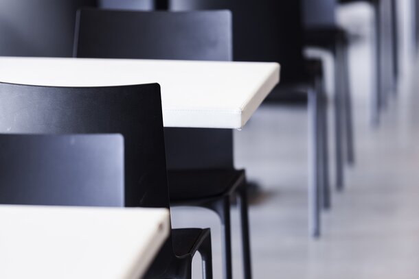 Vue détaillée de rangées de tables blanches et chaises noires