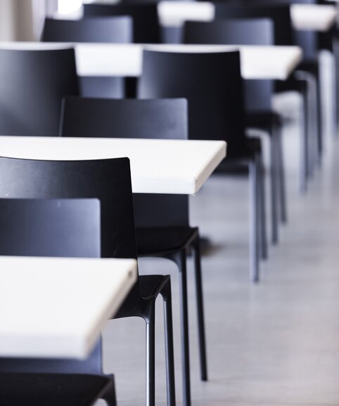 Vue détaillée de rangées de tables blanches et chaises noires