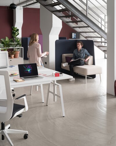 Zwei Personen in großem hellen Büro mit etio Schreibtisch. 