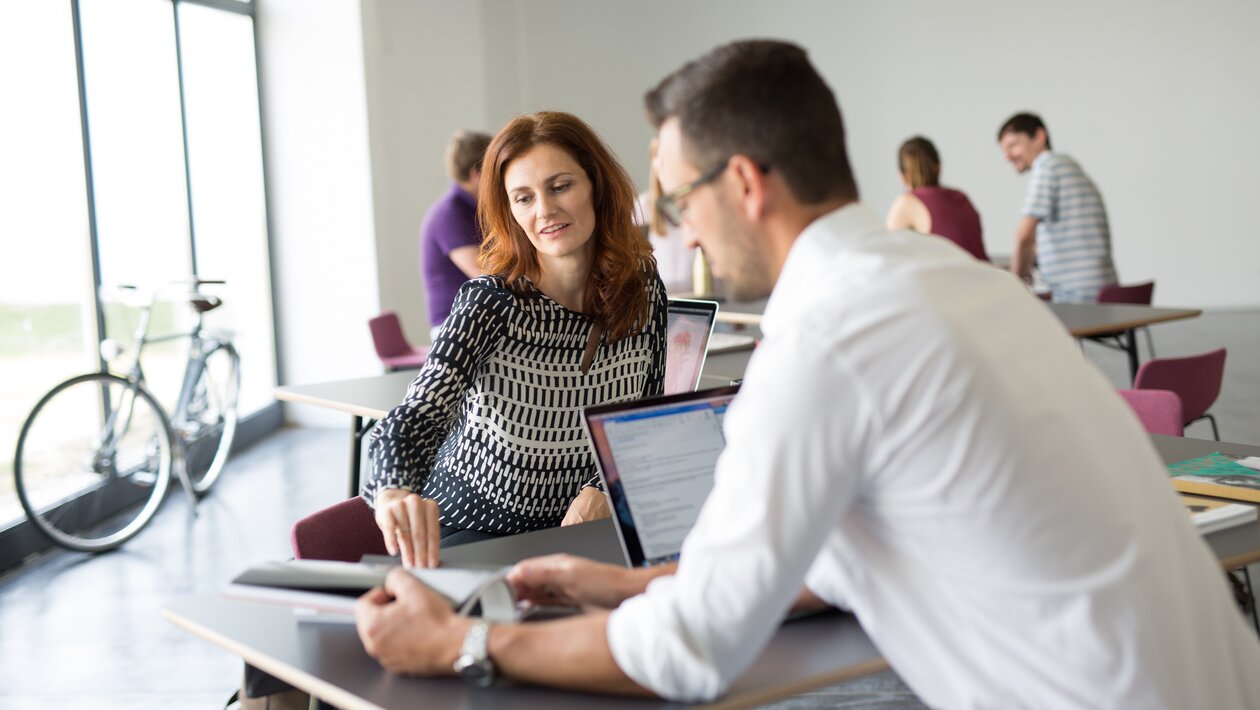 Two people working together.