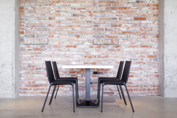 Vue latérale d'une table avec plateau blanc et chaises noires