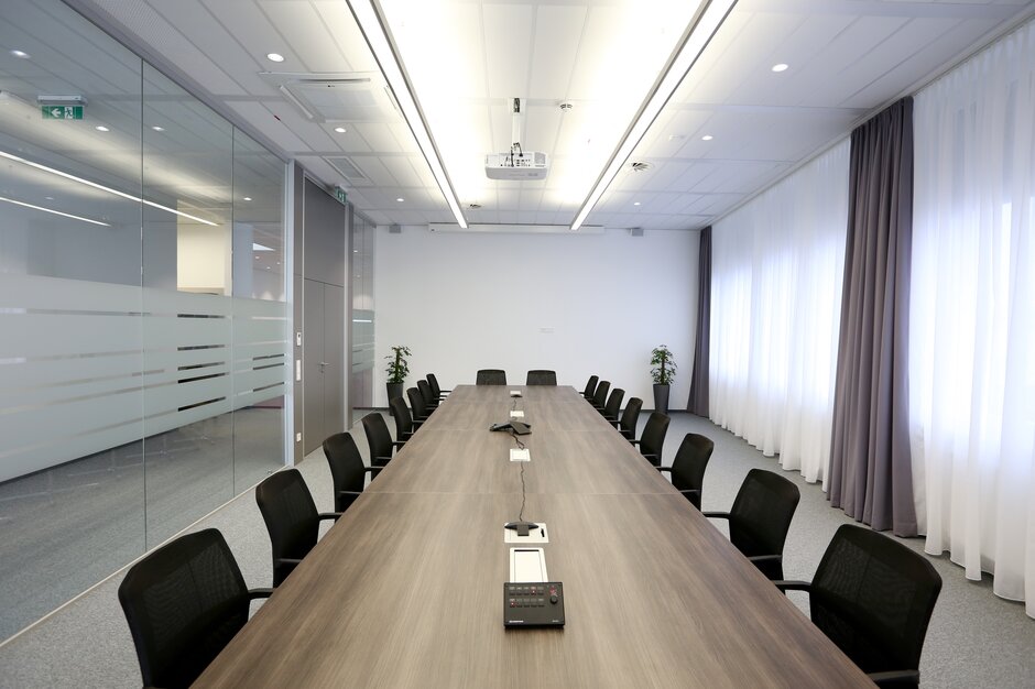 Conference room with a big table and black cantilever chairs. 