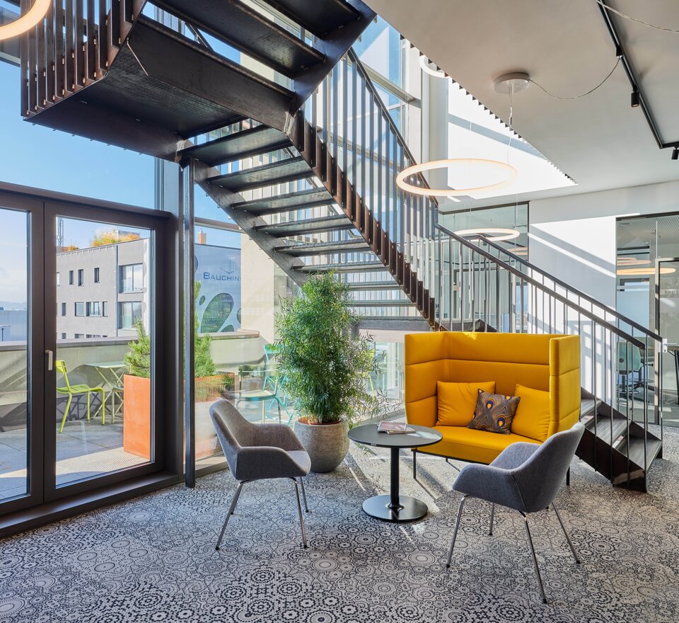 Yellow lounge seating with two gray conference chairs. | © raumpixel.at