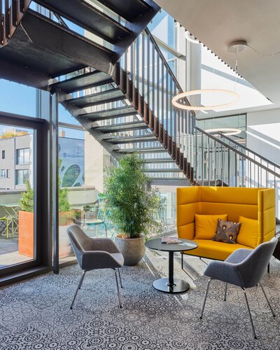 Yellow lounge seating with two gray conference chairs. | © raumpixel.at